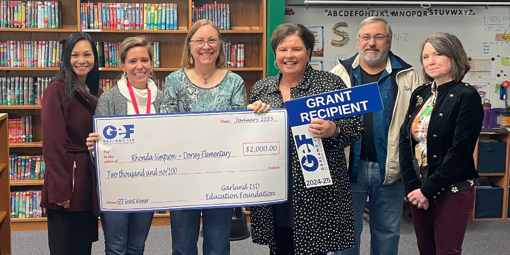 Lisa Cox displays grant check with Rhonda Simpson and guests